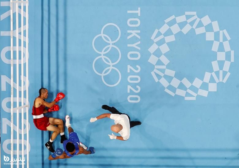 الدریک سلا رودریگز از تیم المپیک پناهندگان پس از زمین خوردن در هنگام مبارزه با یوری سدنو مارتینز از جمهوری دومنیکن روی زمین افتاده است