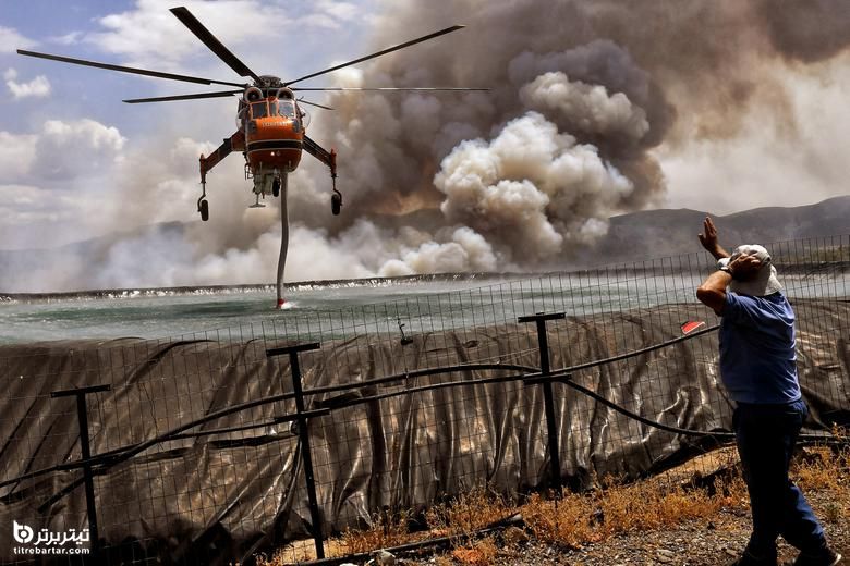 هلیکوپتر پر از آب می شود زیرا آتش سوزی در نزدیکی روستای Spathovouni ، نزدیک کورینت ، یونان ، 23 ژوئیه 2021 انجام می شود