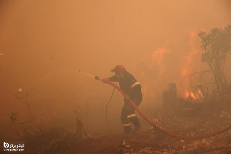 یک آتش نشان تلاش می کند آتش سوزی در روستای گالاتسونا ، در جزیره اوویا ، یونان را خاموش کند.
