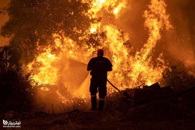 یک آتش نشان تلاش می کند آتش سوزی در روستای پفکی ، در جزیره اوویا ، یونان را خاموش کند.