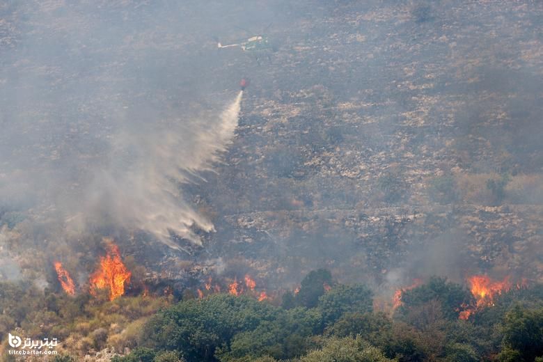هلیکوپتر آب را برای مهار آتش سوزی در منطقه حفاظت شده Monte Castillo در Tivoli ، نزدیک رم ، ایتالیا ، 13 آگوست