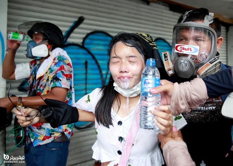 یک تظاهرکننده در طول اعتراض برای رسیدگی دولت به همه گیری ویروس کرونا ، در بانکوک ، تایلند ، کمک می گیرد