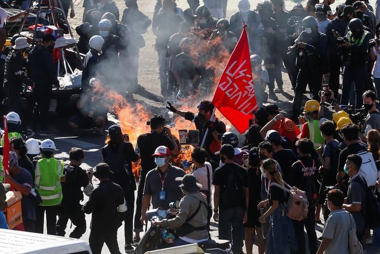 تظاهرکنندگان در اعتراض به برخورد دولت با همه گیری کرونا در کنار آتش ایستاده اند