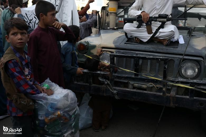 کودکان افغان به سلاح های جنگجوی طالبان در کابل نگاه می کنند