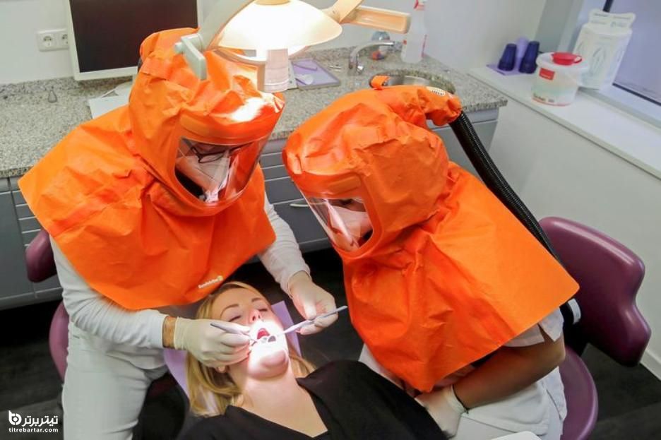 معالجه یک بیمار در کلینیک دندانپزشکی در آلمان با لباس مخصوص