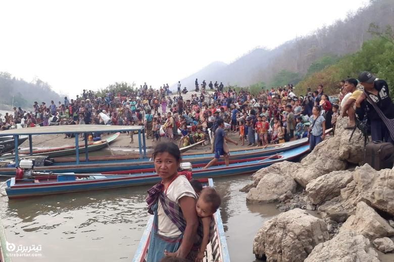 پناهندگان در حال حمل دارایی های خود در ساحل رودخانه ای در تایلند