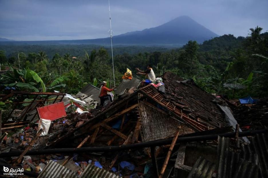 مردم وسایل خود را از خانه آسیب دیده در اثر زلزله در اندونزی نجات می دهند