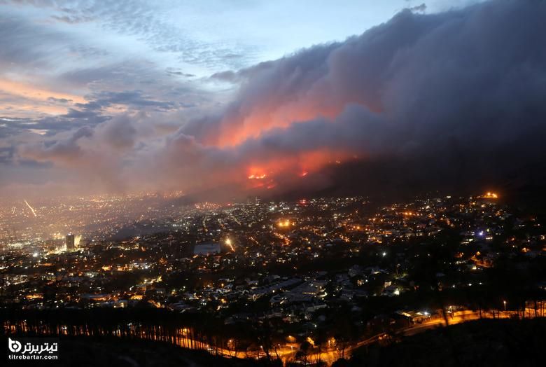 نمایی از شعله های آتش در نزدیکی شهر پس از آتش سوزی در دامنه های کوه تیبل در آفریقای جنوبی
