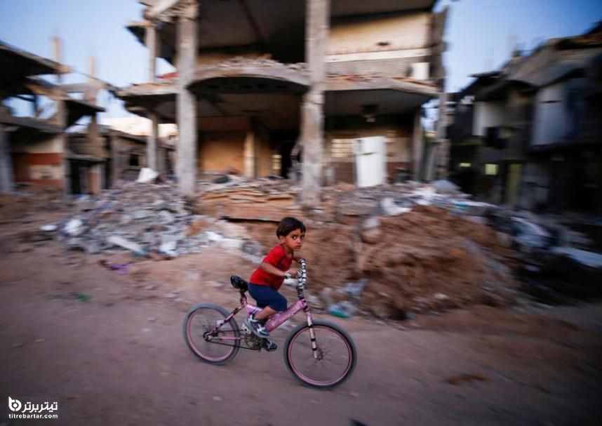 دوچرخه سواری یک کودک فلسطینی در خرابه‌های حملات هوایی رژیم صهیونیستی در نوار غزه