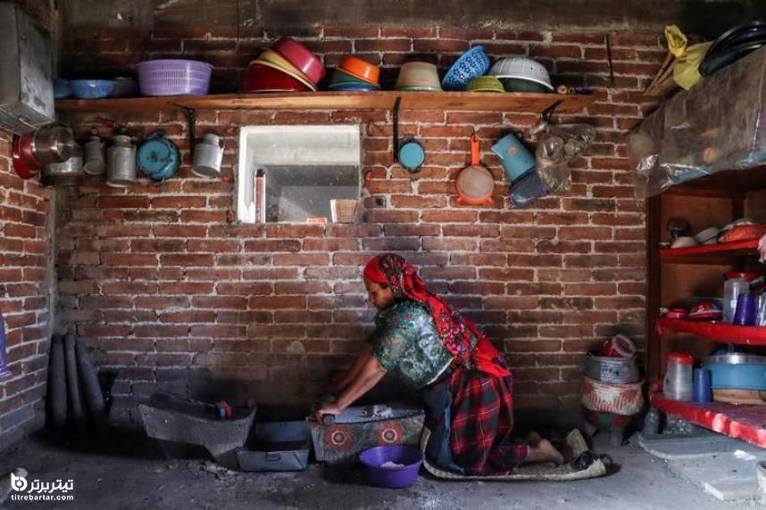 زن بومی در دهکده روستایی در مکزیک در حال خرد کردن ذرت