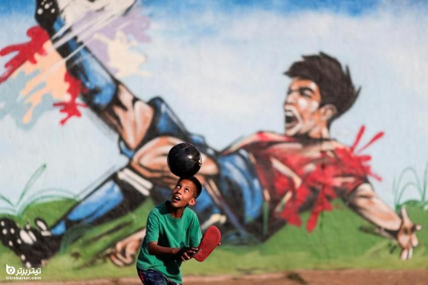 فوتبال بازی پسری در یکی از خیابان‌های برزیل