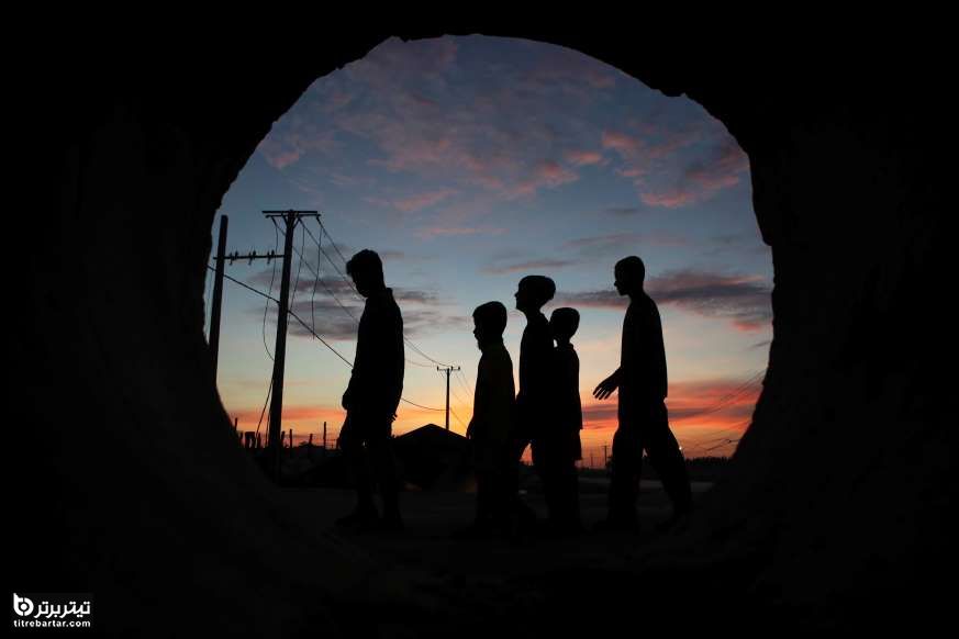 چند پسر بچه در مقابل یک تونل، پس از جشن مقدس بودایی، کامبوج 