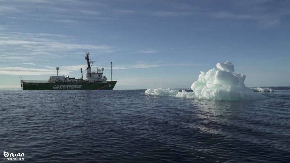 یک کشتی در نزدیکی تکه یخ شناور در اقیانوس منجمد شمالی 