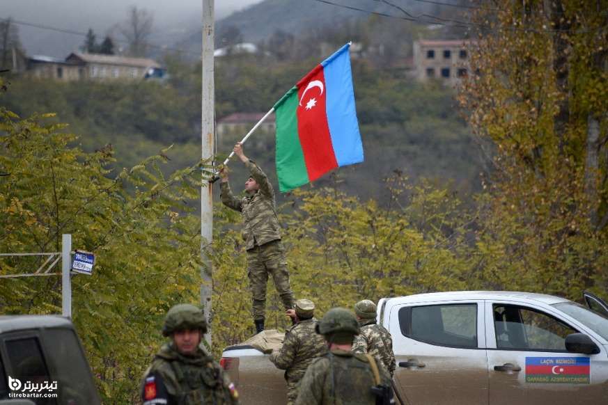 سرباز آذربایجانی درحال نصب پرچم این کشور بر روی تیر چراغ برق در شهر لاچین 