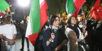 عکس | تصویری متفاوت از دو دختر در تجمعات تهران؛ نوشته معنادار خطاب به ترامپ با پرچم حزب الله و جمهوری اسلامی ایران